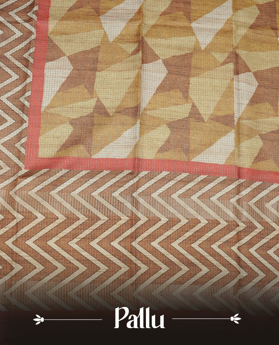 Rust brown colour semi tussar silk saree featuring bold zigzag geometric prints across the body, highlighted with a contrasting coral-red border and detailed pallu, paired with a matching printed blouse piece.