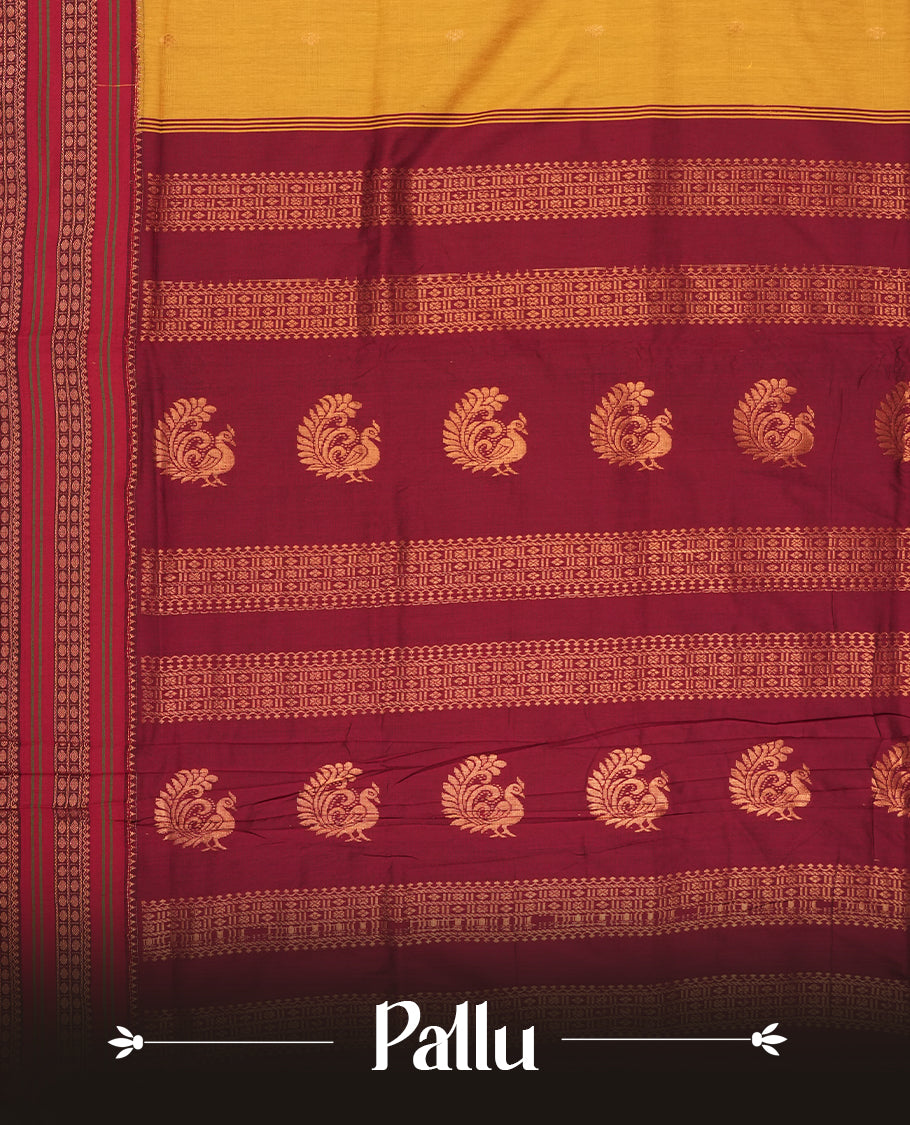Mustard yellow Kalayani cotton saree with delicate woven motifs on the body, enhanced by a rich maroon contrasted zari border and pallu with traditional patterns, paired with a matching blouse piece.