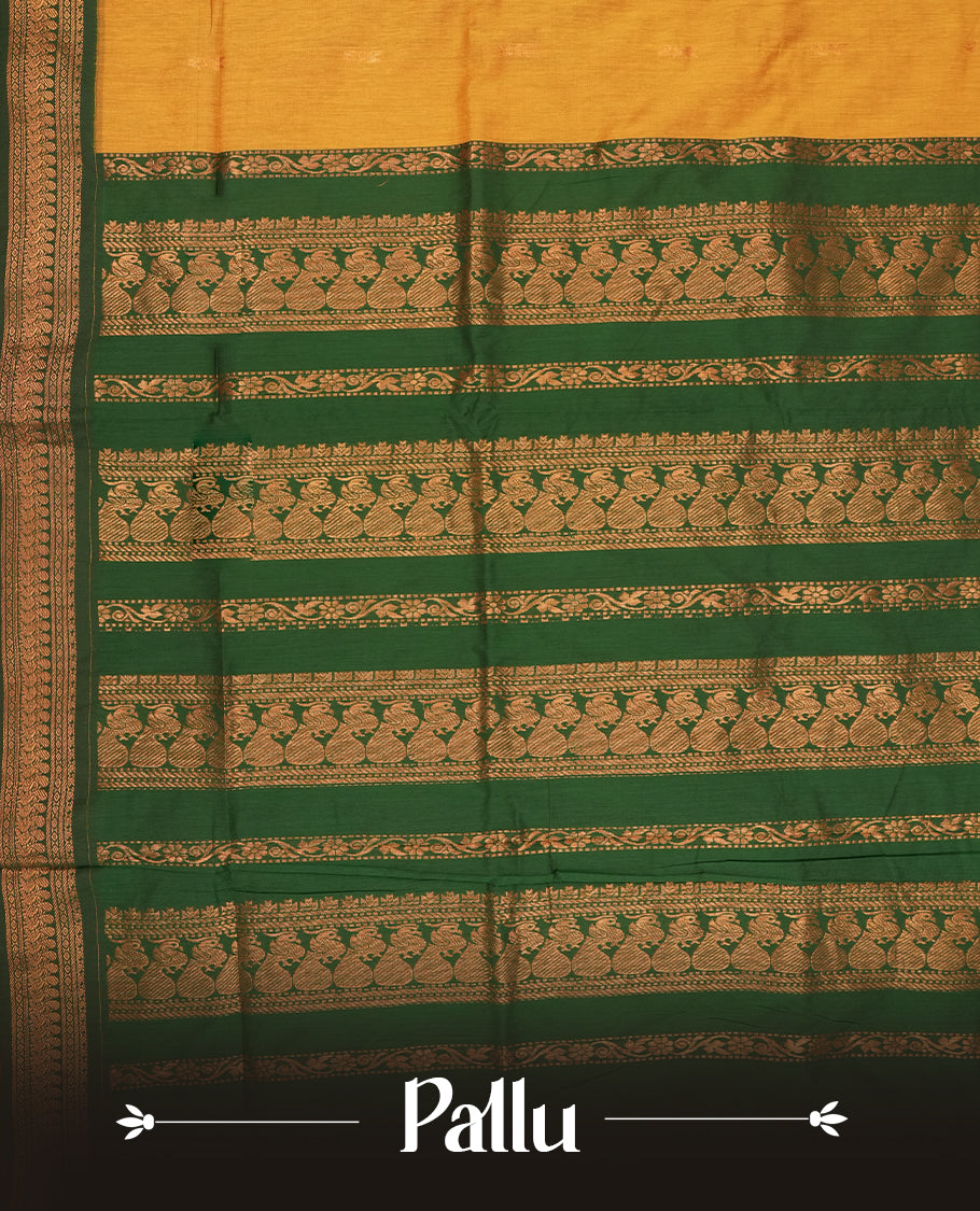 Mustard yellow colour Kalyani Cotton saree with rich green border and pallu, featuring copper zari motifs and intricate weaving & Includes a matching blouse piece.