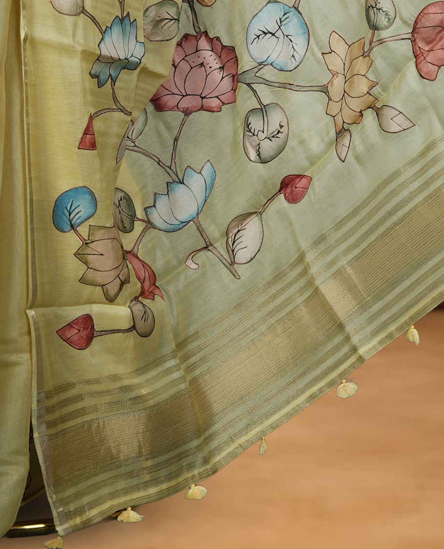 Pastel yellow colour semi tusser silk saree featuring delicate hand painted floral motifs along the pallu and border finished with subtle tassels and paired with a matching blouse.