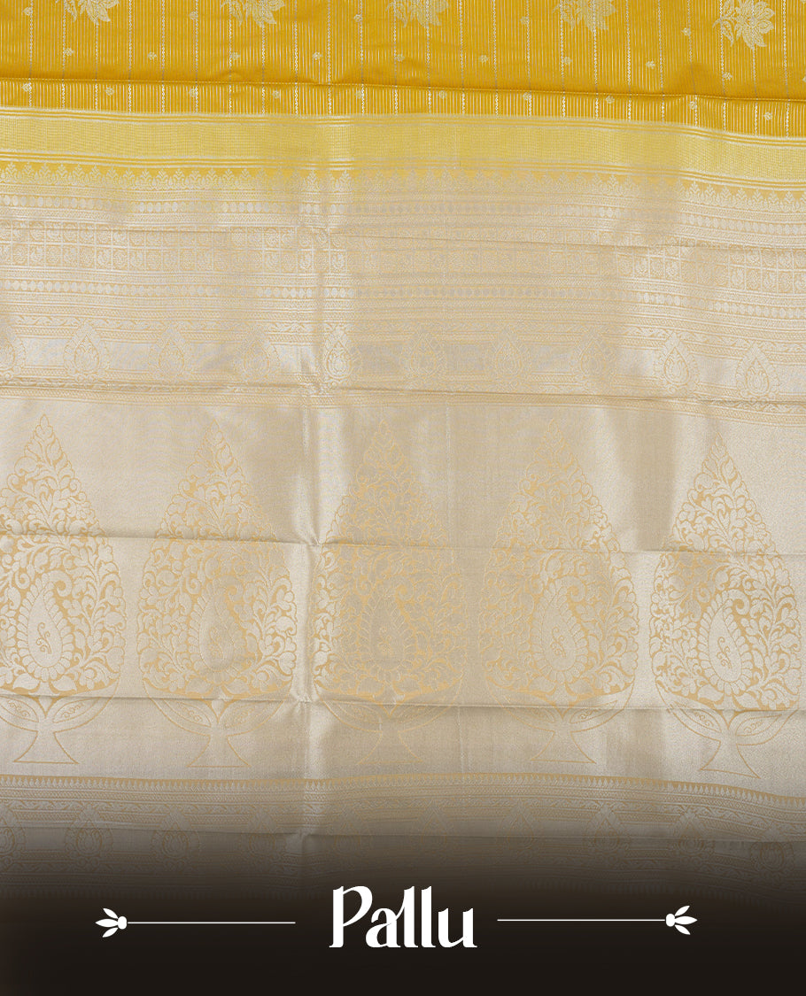 Light olive yellow colour Semi Silk Saree featuring silver zari floral motifs on the body, complemented by a muted brown traditional pallu and border, and paired with a matching blouse piece.