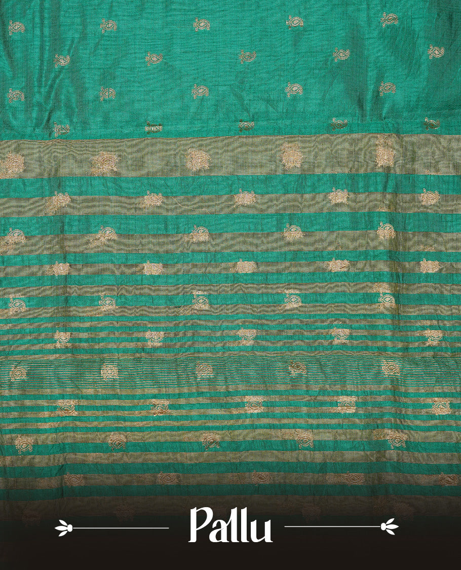 Green colour semi tussar silk saree featuring small gold zari mango motifs across the body, enhanced with a self colour border showcasing elegant gold zari mango patterns. Paired with a matching blouse piece.