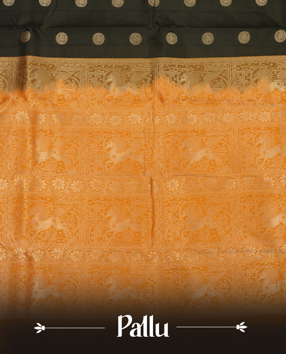 Black colour Vasundhara silk saree adorned with all-over gold chakkaram motifs on the body, complemented by a contrast turmeric colour with gold flower kodi motifs border and paired with a matching blouse piece.