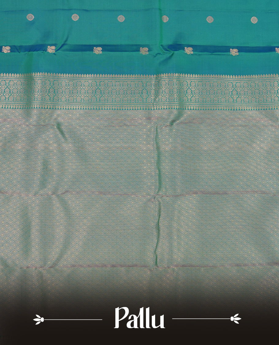 Peacock green colour Vasundhara silk saree adorned with all-over gold chakkaram& mayil motifs on the body, complemented by a self colour with rose gold traditional border and paired with a matching blouse piece.