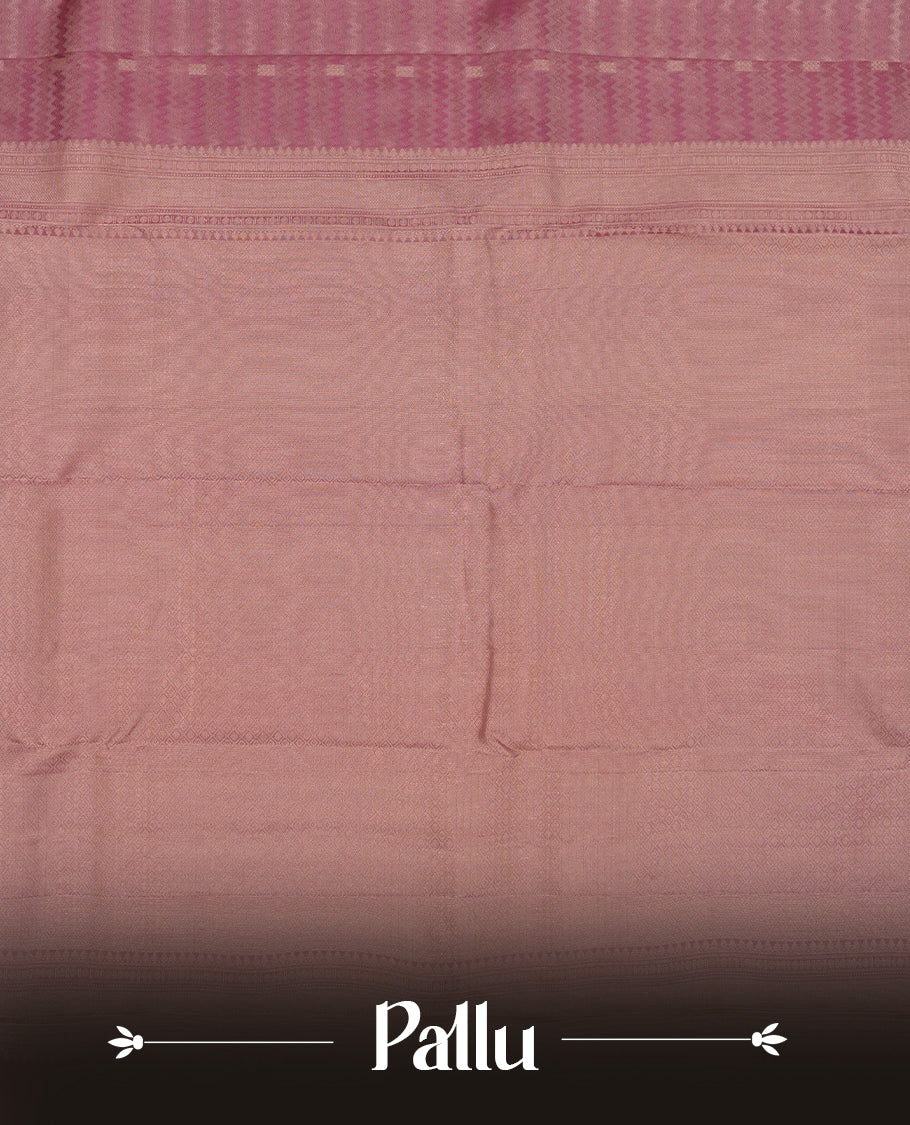 Dusty purple colour Vasundhara silk saree adorned with all-over zigzag motifs on the body, complemented by a self colour with gold line pattern border and paired with a matching blouse piece.