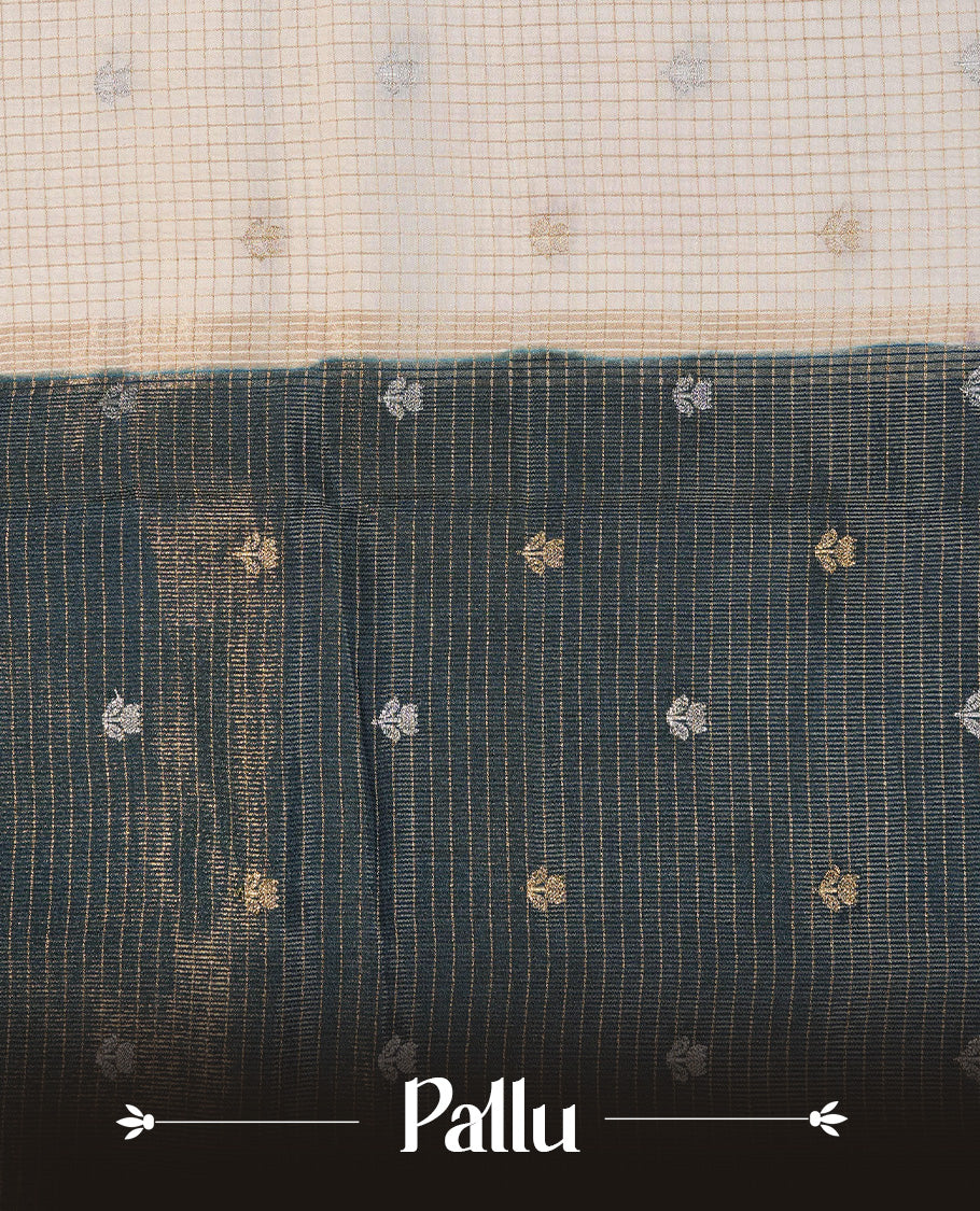 Semi Banaras Tussar Saree Featuring Gold Zari Check With Floral Pattern On Body , Teal Blue Colour With Gold Zari Border , Paired With A Matching Blouse Piece.