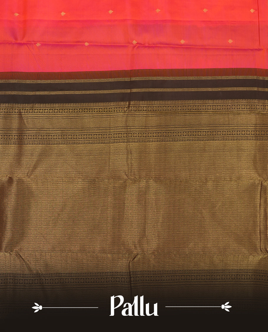 Pinkish red colour Vasundhara silk saree adorned with all-over gold zari motifs on the body, complemented by a contast black colour with gold motifs on border and paired with a matching blouse piece.