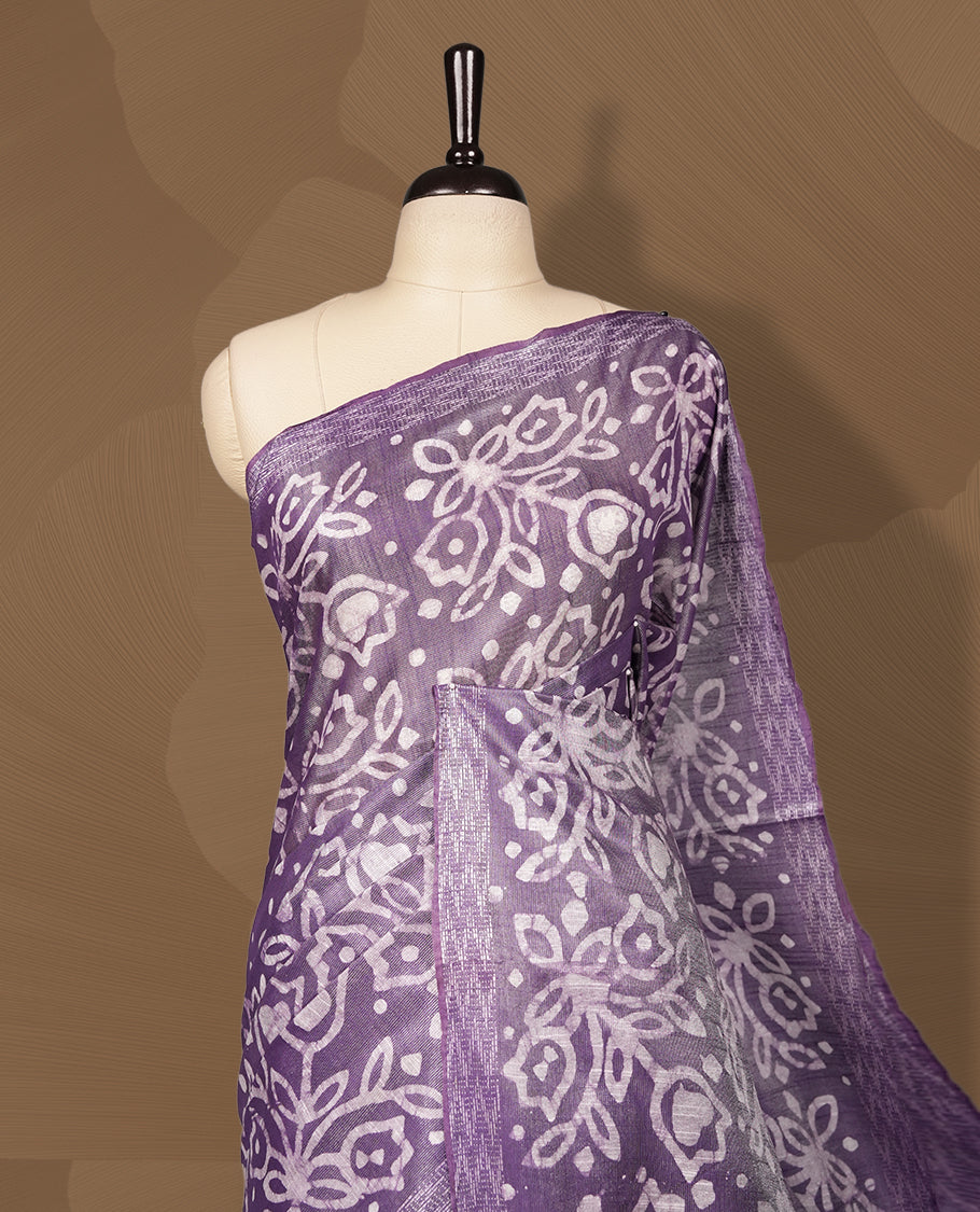 Lavender semi jute tissue saree adorned with elegant white floral motifs all over the body, paired with a beautifully woven pallu and patterned borders & Comes with a matching blouse piece.