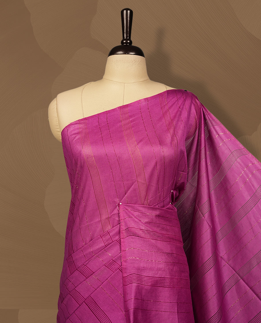 Magenta colour semi jute saree featuring subtle woven patterns and fine thread striped detailing, finished with tassels on the pallu & Comes with a matching blouse piece for a graceful traditional look.