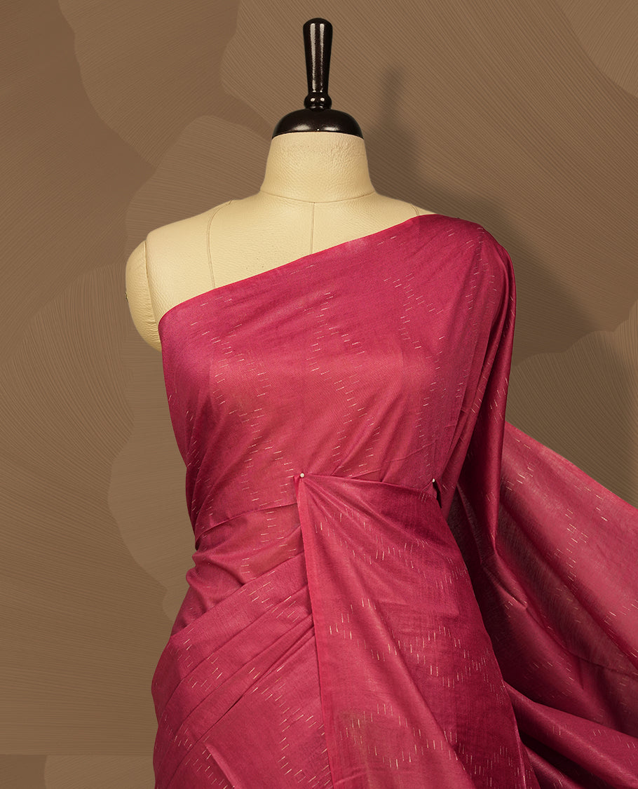 Crimson red colour semi jute saree featuring subtle linear woven motifs across the body, Enhanced with a finely crafted pallu and sleek border & Comes with a matching blouse piece for a complete look.