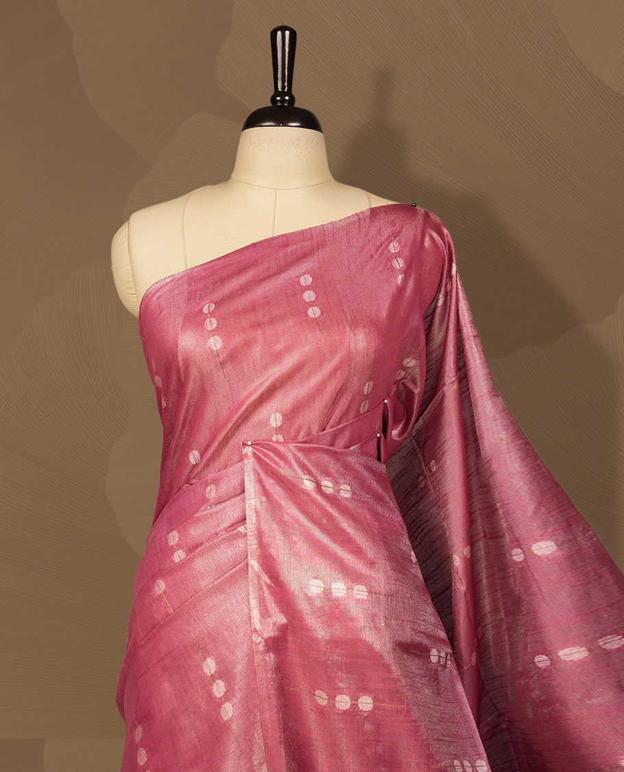Onion pink colour semi jute saree featuring subtle dotted woven patterns on the body, complemented by a shimmering pallu & Comes with a matching blouse piece for a complete look.