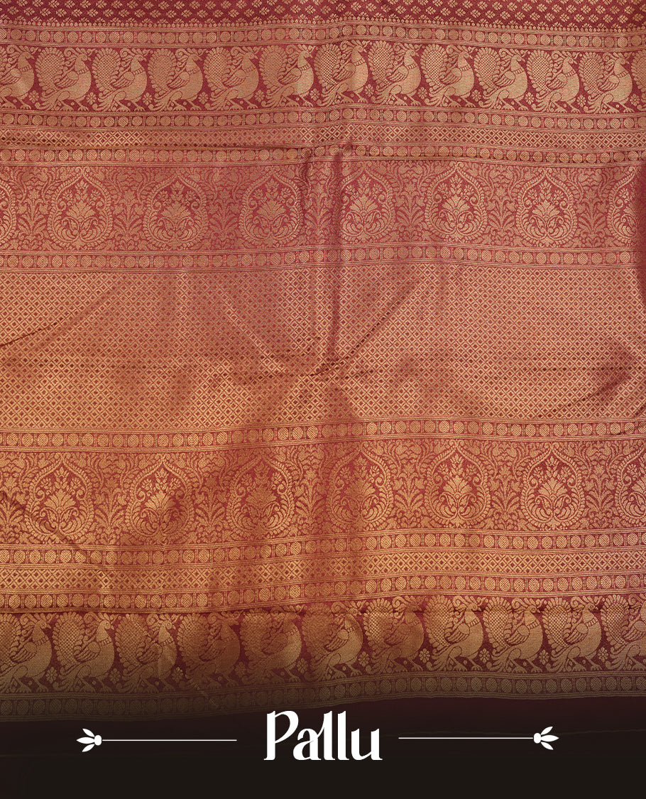 Maroon colour semi soft silk saree featuring gold zari motifs on across body, self colour border with traditional gold zari pattern, pallu and paired with matching blouse.