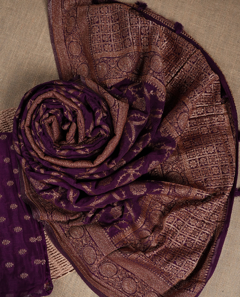 Grape colour suit material adorned with delicate golden motis & zari work & Comes with a beautifully woven dupatta and matching plain bottom fabric.