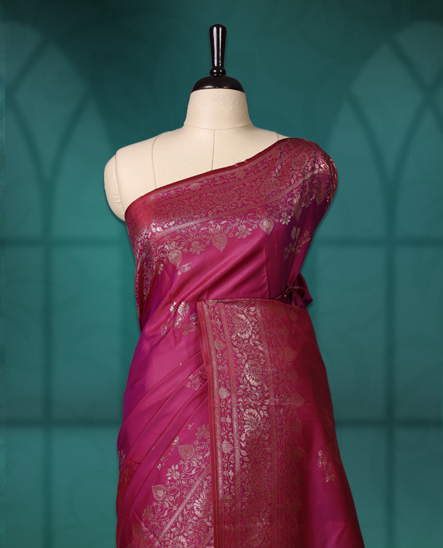 Pink colour semi silk saree featuring intricate golden zari floral motifs across the body, complemented by a rich maroon woven border and pallu, paired with a matching blouse.