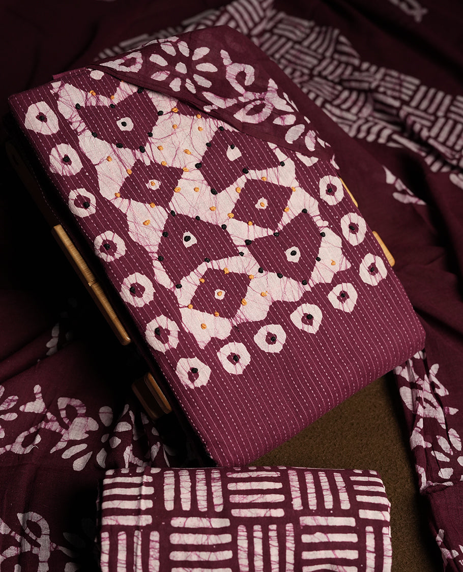 Wine & Off white cotton churidar material adorned with black & yellow colour thread work on the neckline, featuring traditional tie dye patterns and a stripped body & Comes with a matching printed dupatta and coordinated printed bottom.