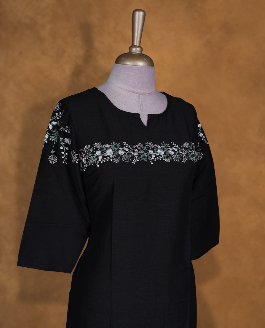 Black colour kurti by Talisha with round notch neckline, delicate floral yoke embroidery extending to the sleeves, straight calf‑length silhouette, and elbow‑length sleeves.