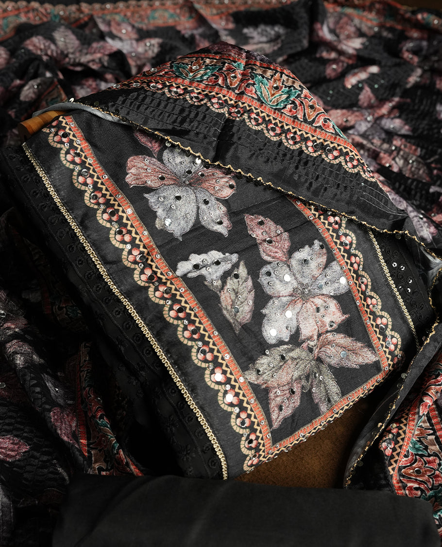 Black colour churidhar material featuring Mirror and thread embroidery, foral print pattern on the self colour front panel, floral digital printed dupatta with elegant border, and matching plain bottom