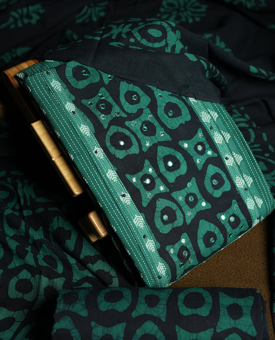 Peacock green and Navy blue colour cotton churidar material featuring embroidery striped body with mirror work on the neckline, highlighted with traditional tie dye patterns & Paired with a matching printed dupatta and printed bottom.