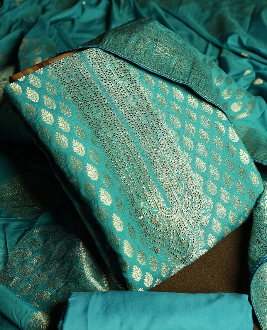 Turquoise blue colour churidar material featuring elegant golden stone work on the neckline, adorned with zari leaf motifs all over & Paired with a rich zari woven dupatta and a matching plain fabric for the bottom.