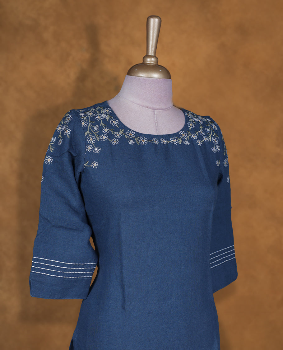 Deep blue colour kurti by Talisha with round neckline, delicate white floral embroidery on the neck and sleeves, straight calf‑length silhouette, and three‑quarter sleeves with contrast stripe cuffs.
