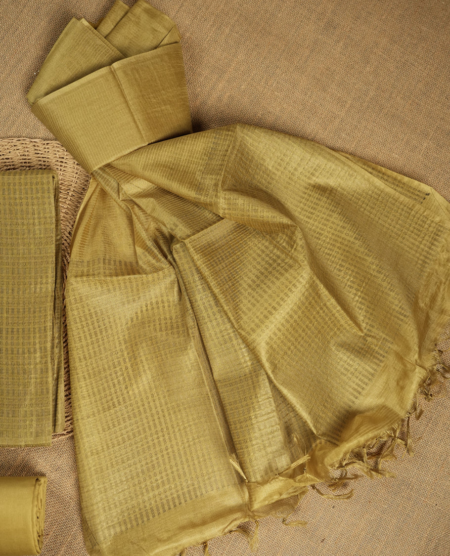 Citrine yellow tussar suit material featuring a subtle self check woven pattern on the body, paired with a lightweight matching dupatta with tassel edges and a plain bottom piece.
