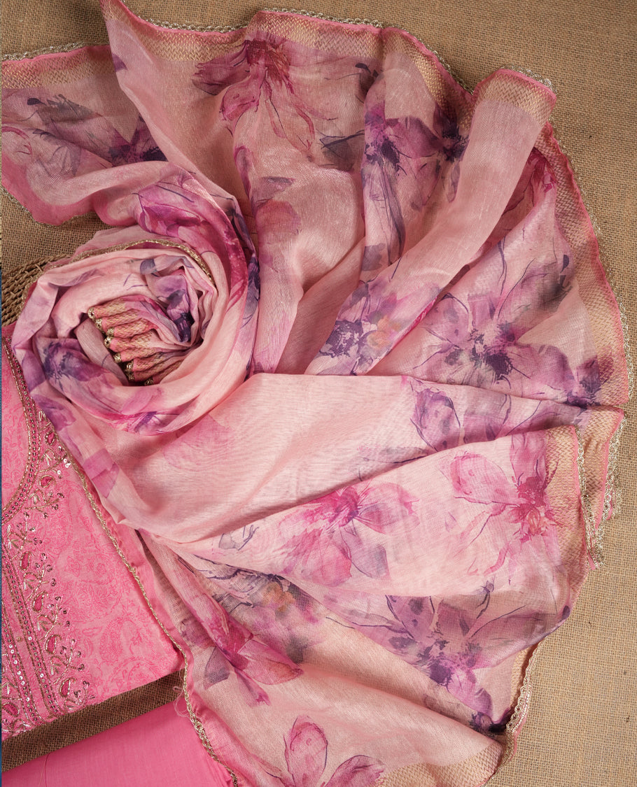 Pink colour suit material adorned with sequins and cut beads embroidery work on the neckline, exuding a graceful charm & Paired with a floral printed dupatta and a matching plain bottom.