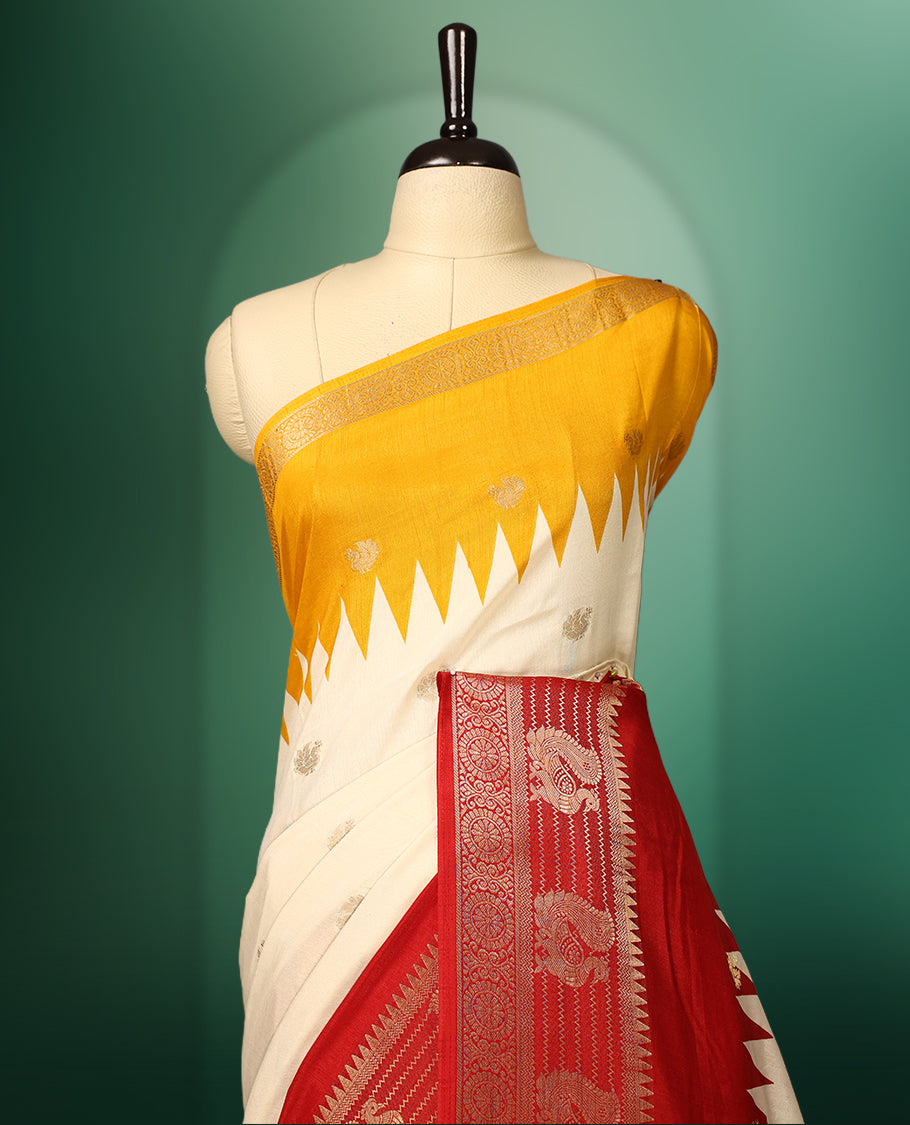 Cream and yellow colour saree featuring a rich red zari woven border and pallu, adorned with traditional floral motifs, and paired with a matching blouse