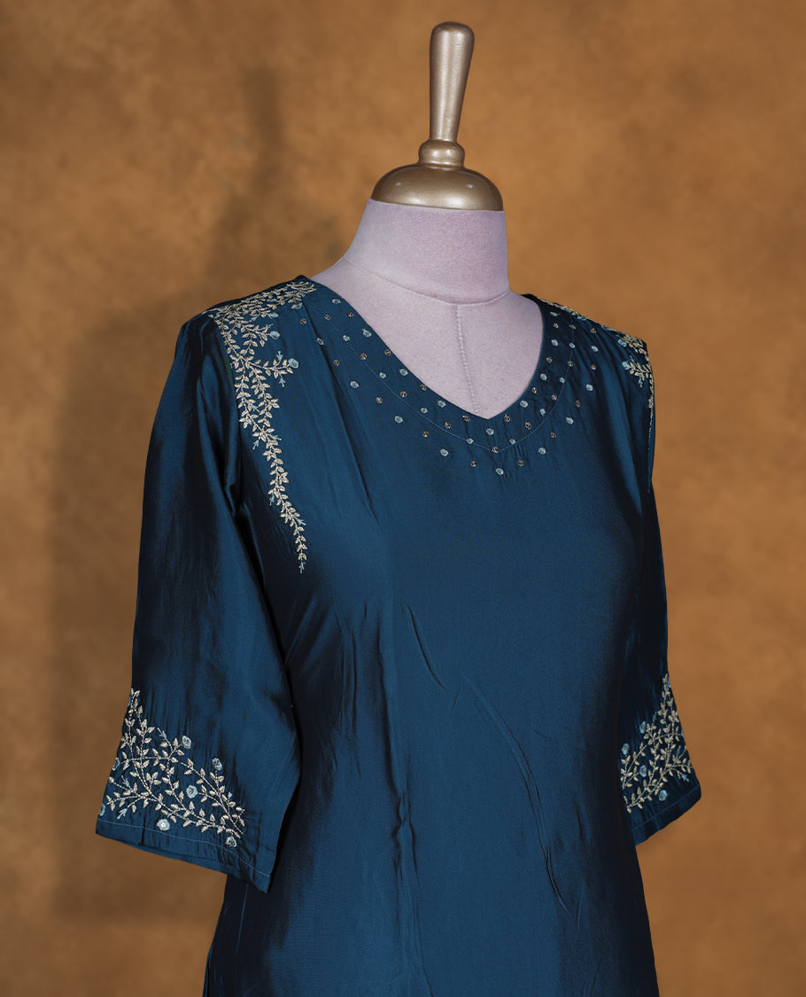 Teal blue colour kurti by Talisha with V neckline, scattered stud detailing on the yoke, A‑line calf‑length silhouette, and three‑quarter sleeves featuring delicate floral embroidery.