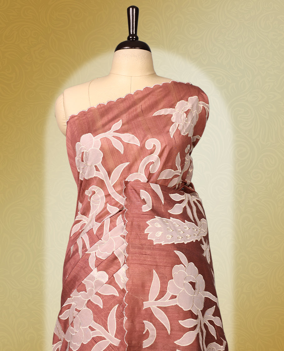Mauve colour semi tussar saree adorned with elegant white applique work in leaf and floral designs across the body and border, paired with a matching blouse.