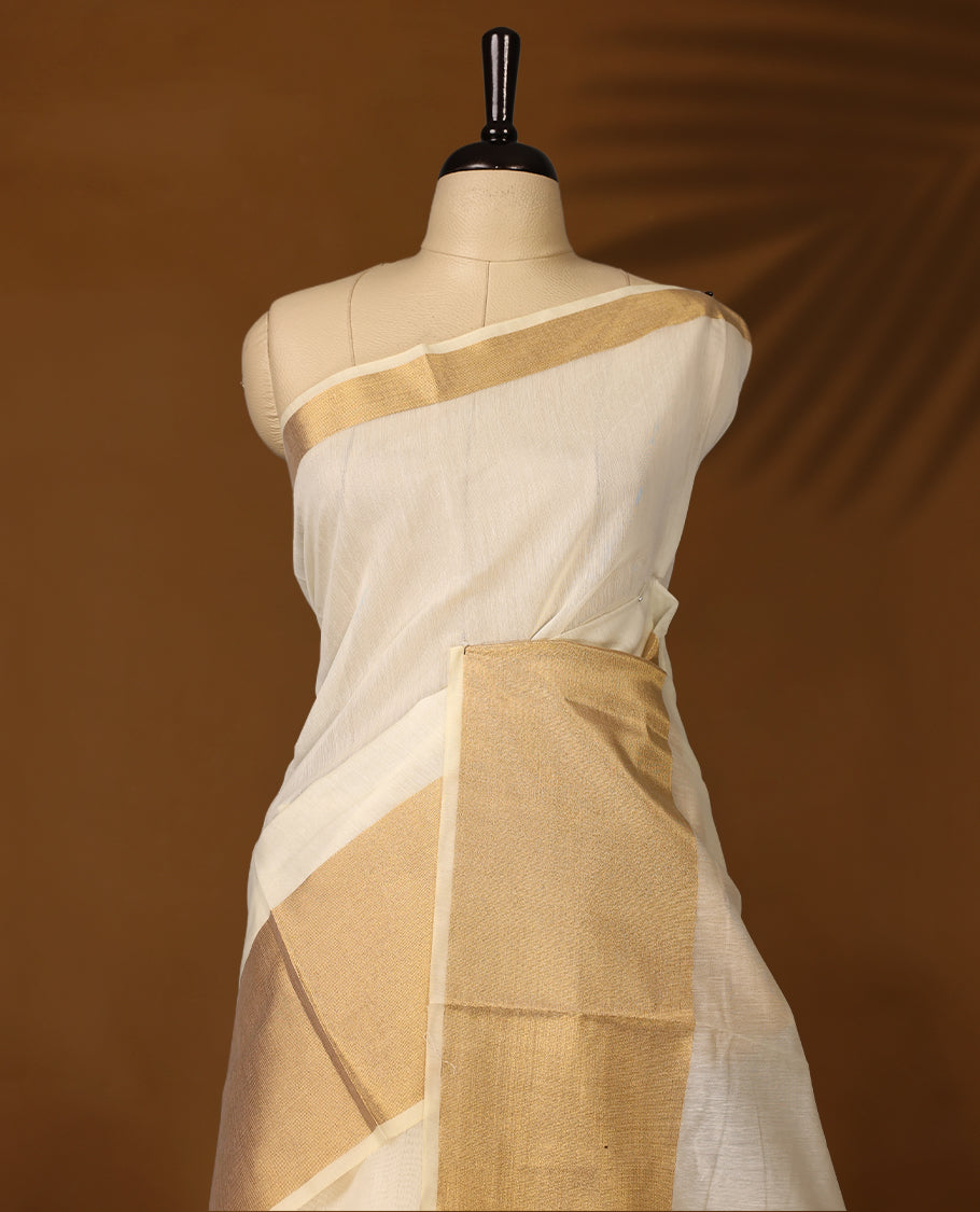 Elegant Off white colour Kerala saree with a traditional golden zari border and pallu, finished with golden tassels & A timeless ethnic piece, perfect for festivals and celebrations, paired with a matching blouse.