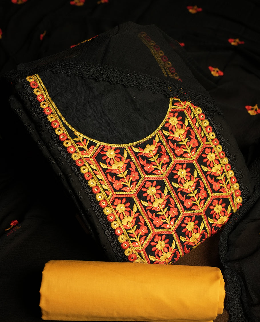Black colour hakoba churidhar material featuring beautiful yellow and orange colour floral embroidery on the neckline and front panel, highlighted with lace detailing & Comes with an embroidered dupatta and contrast yellow bottom.