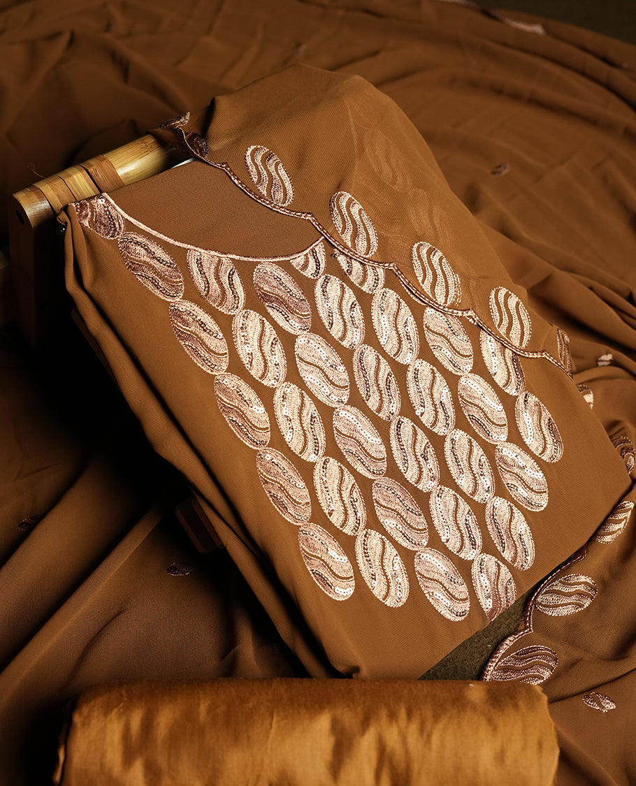 Mustard brown colour churidar material adorned with intricate sequin embroidery on the neckline and body & Accompanied by a matching embroidered dupatta and plain bottom.