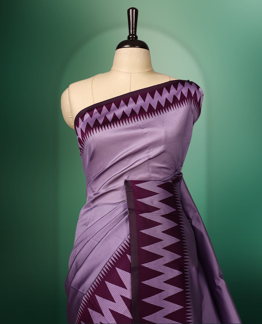 Lavender colour saree accentuated with bold deep purple zigzag woven borders and a contrasting rich copper zari pallu, paired with a matching blouse