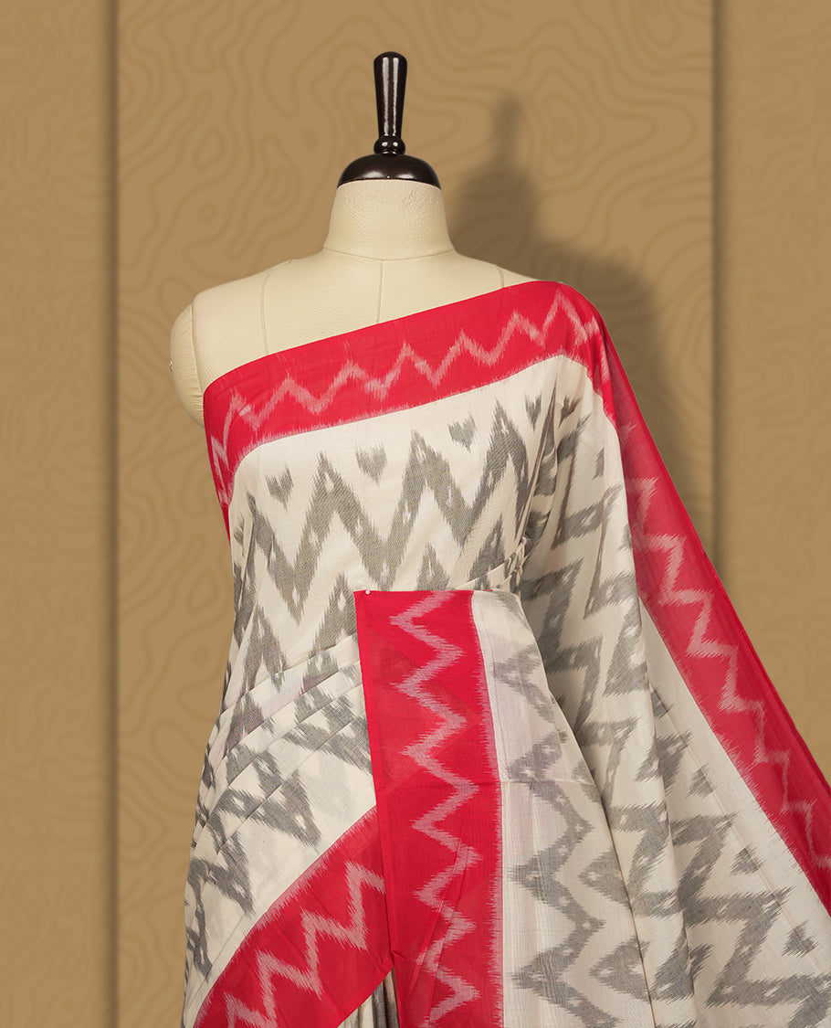 Off white colour Ikkat Pochampally saree with bold grey colour zigzag motifs and contrasting maroon borders, The striking woven pallu enhances its elegance, making it a perfect blend of tradition and style, Paired with a matching blouse.