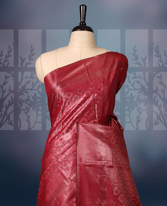 Maroon colour semi silk brocade saree featuring intricate self design brocade patterns across the body, complemented by a rich self colour woven border and pallu, paired with a matching blouse.
