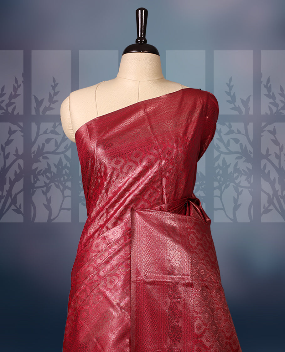Maroon colour semi silk brocade saree featuring intricate self design brocade patterns across the body, complemented by a rich self colour woven border and pallu, paired with a matching blouse.
