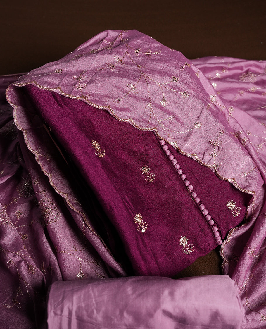 Magenta purple colour churidhar material featuring thread embroidery on the front panel, contrast lavender colour dupatta with elegant border, and matching plain bottom