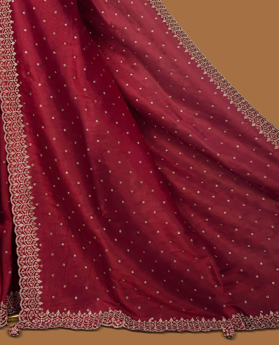 Dark Magenta Colour net shimmer fancy saree adorned with scattered white stone buttas all over the body, paired with a delicate stone worked border and matching blouse featuring floral vine stone embroidery