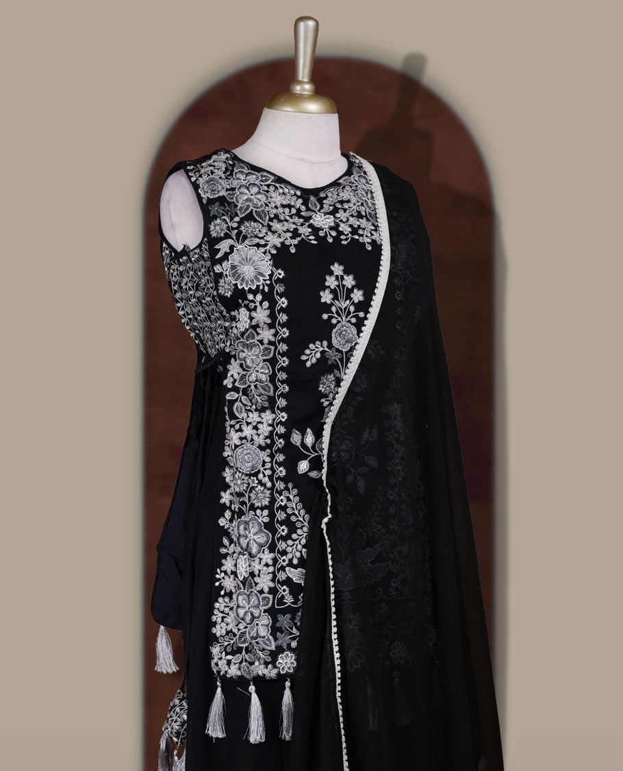 Elegant Black sharara set featuring intricate white floral embroidery,cut beads and small stone work & The outfit includes a beautifully flared bottom for graceful movement and a matching dupatta adorned with tassels for a complete festive look.
