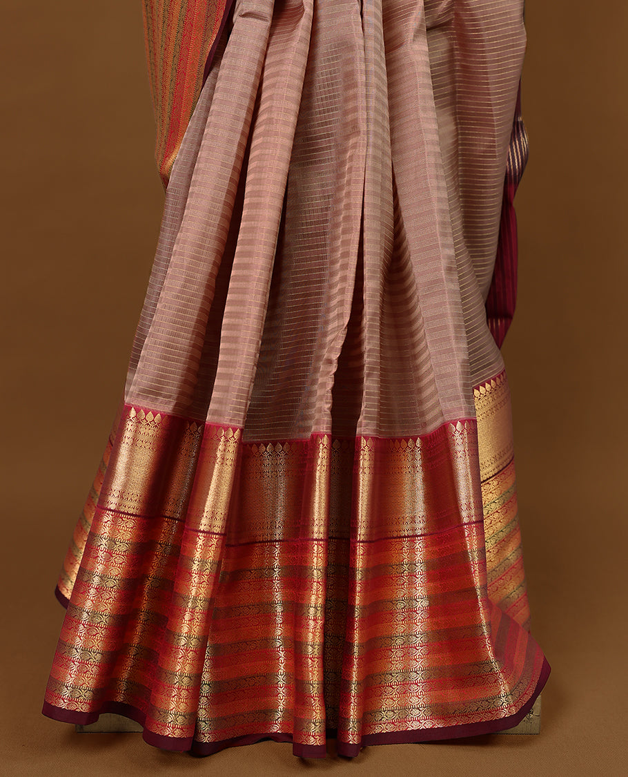 Warm brown Colour soft silk saree with subtle reddish undertones, adorned with golden vertical pinstripes, featuring a contrasting traditional border and paired with a matching blouse.