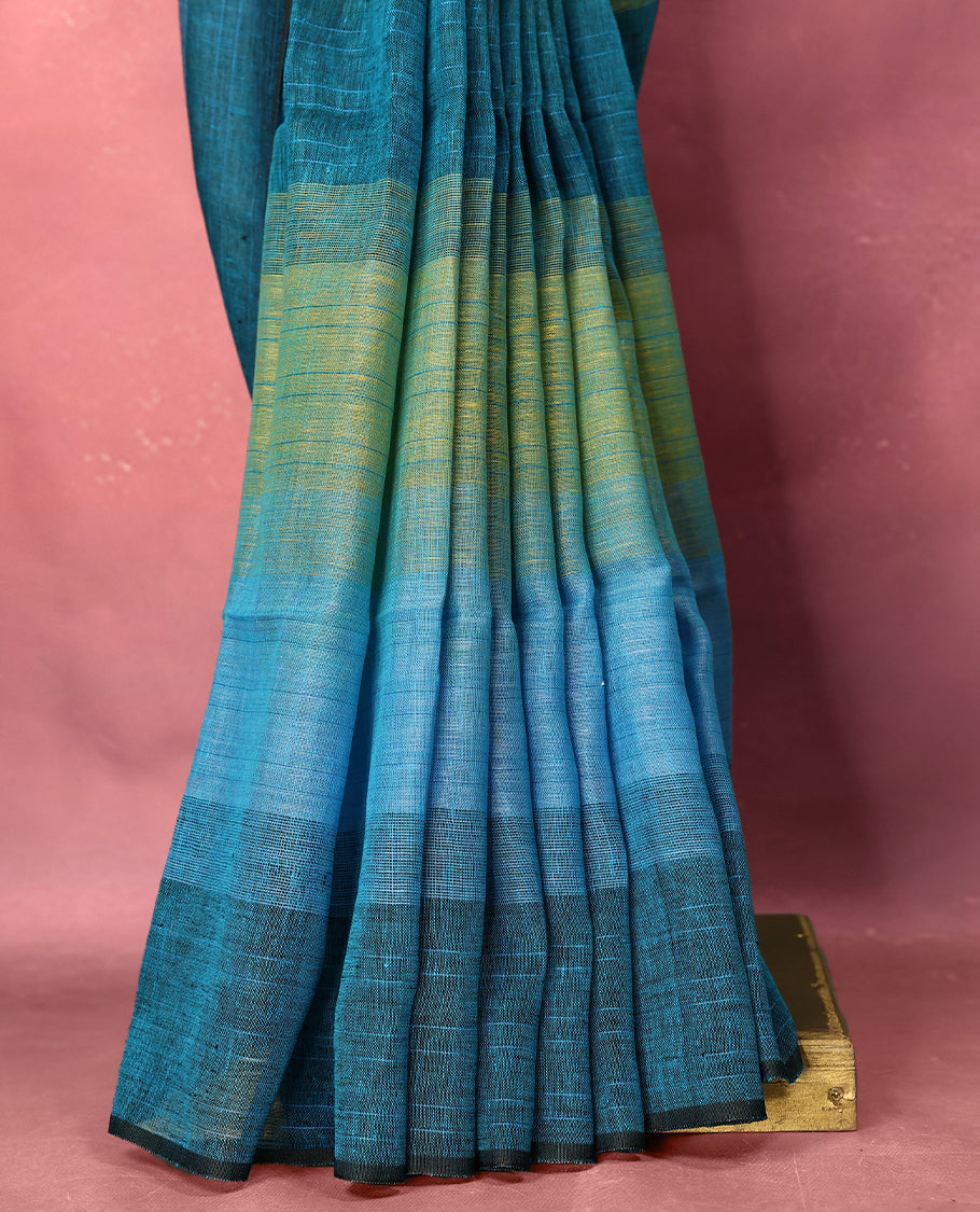 Teal and blue colour pure linen saree featuring broad horizontal stripes in shades of green and sky blue, complemented by a sleek self border and comes with a matching blouse