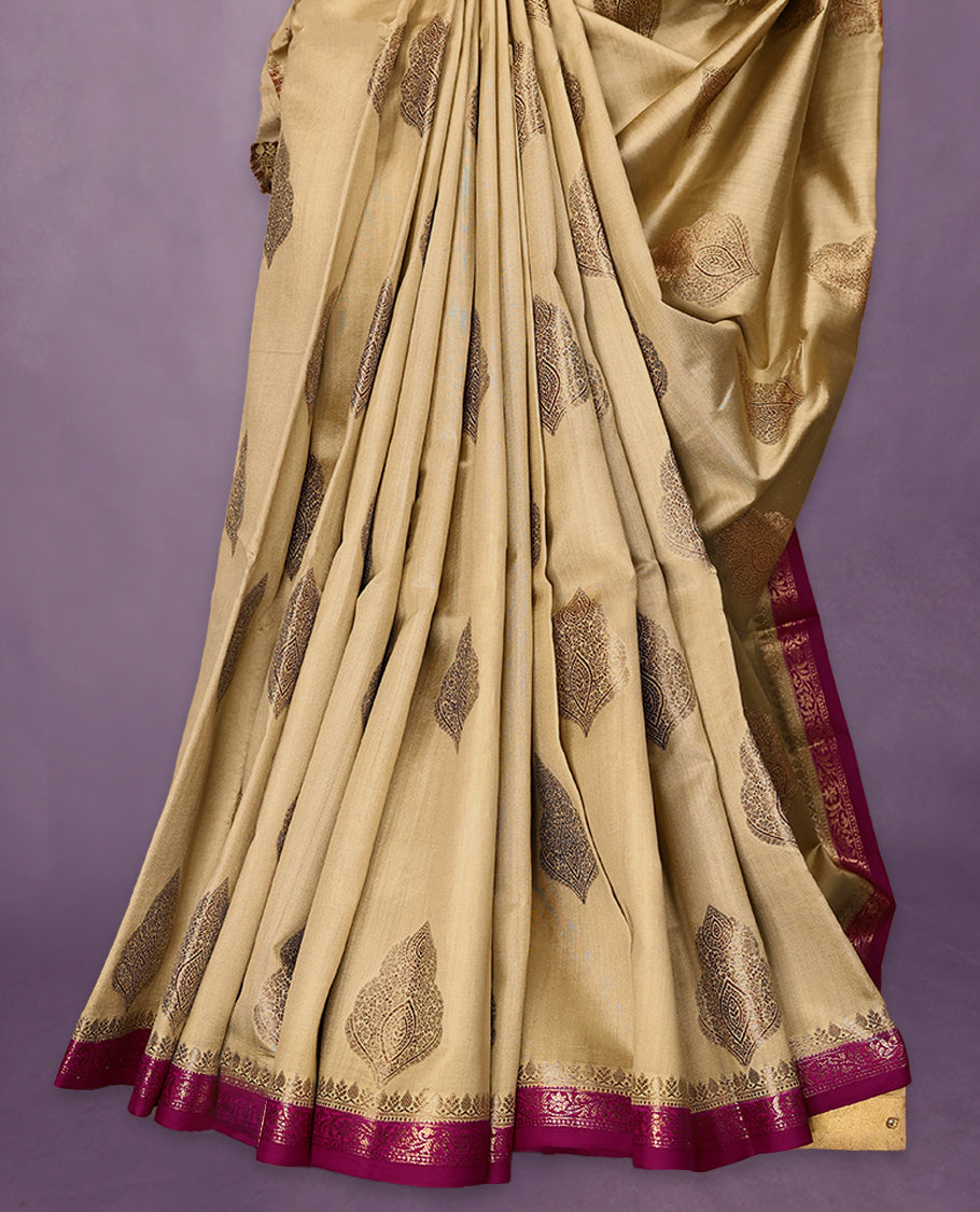 Beige Colour Pure Banaras Soft Silk Saree adorned with traditional antique zari motifs, paired with a hand dyed Dark Magenta antique style border and a matching blouse.
