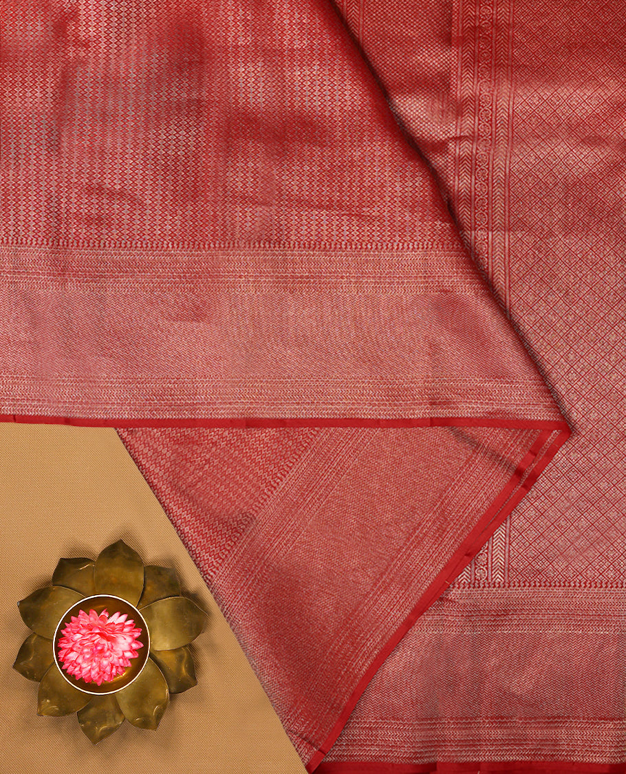 Red Colour Manthrakodi saree featuring a golden zari brocade body, complemented by a self coloured zigzag brocade border and a matching blouse.