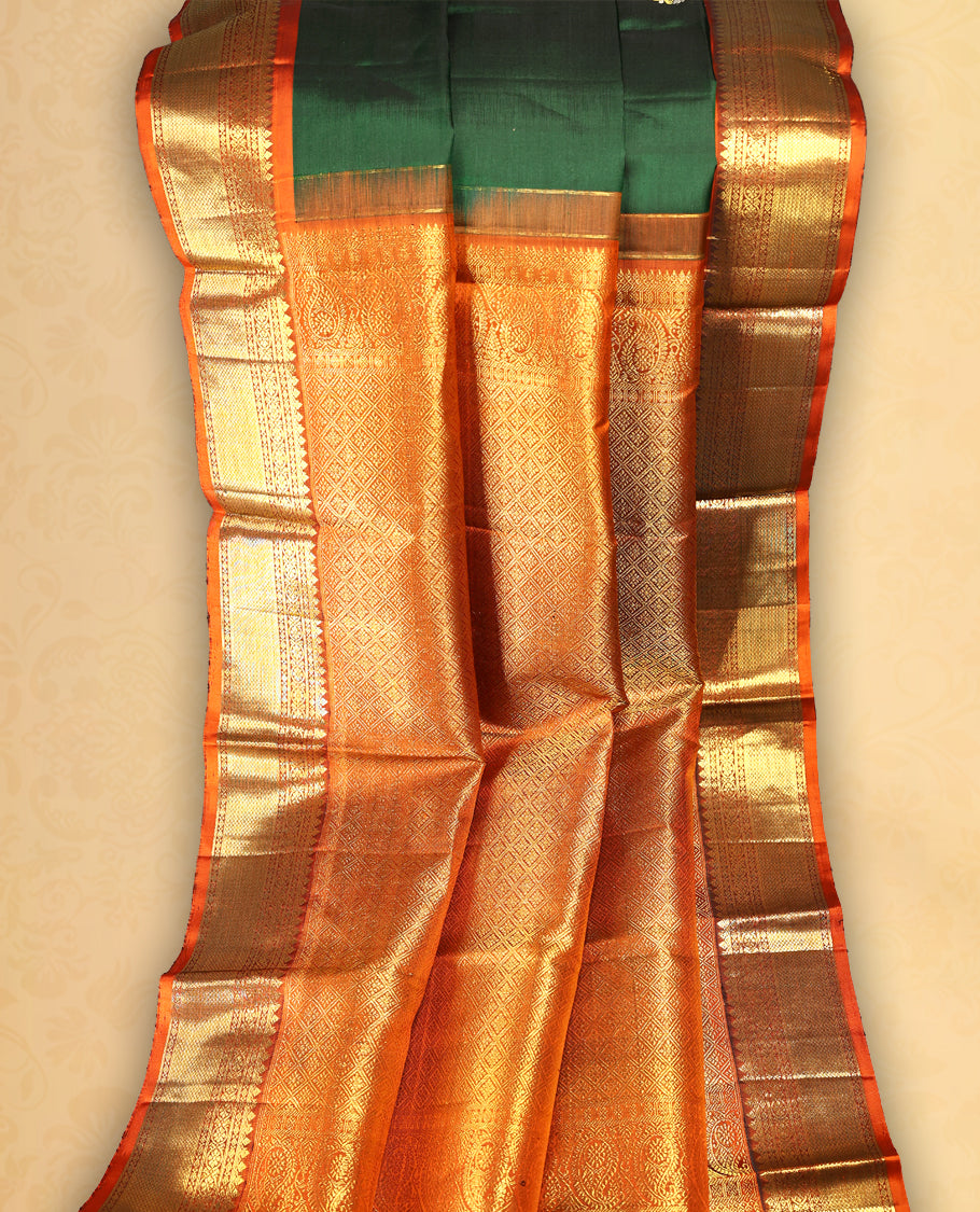 Bottle green colour pure Kancheepuram saree with gold zari traditional paisley motifs on the body contrast traditional border grand pallu with diamond pattern paired with matching blouse