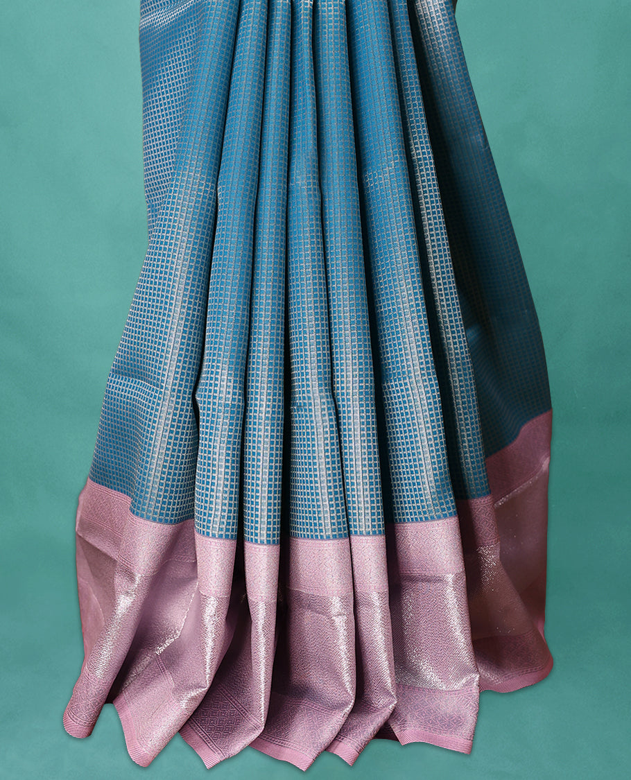 Blue coloured semi silk saree featuring a Check design on the body, paired with a Pastel Pink coloured border and matching blouse.