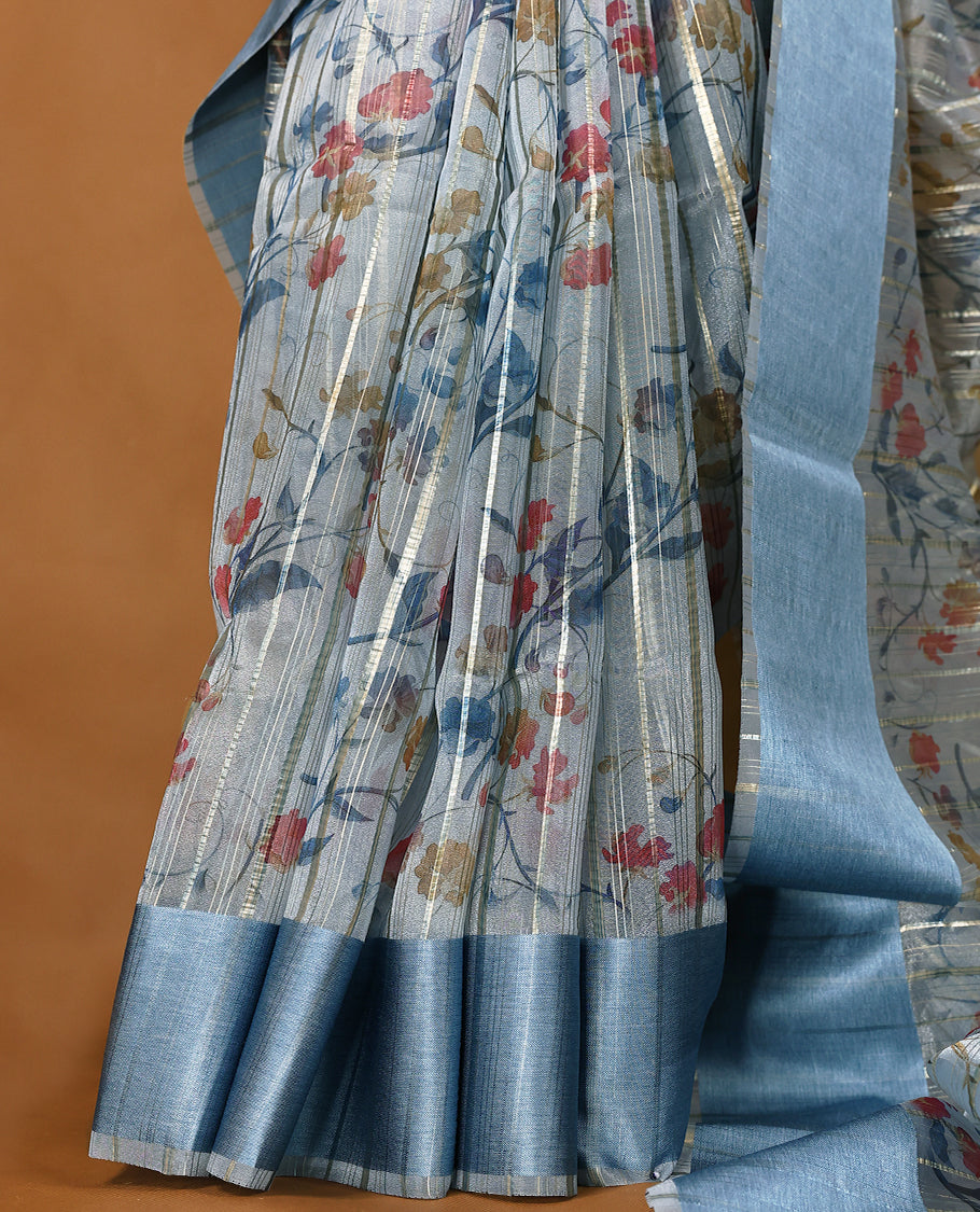 Blue semi-organza saree with intricate floral jaal work, elegant border, and a matching silk brocade blouse.
