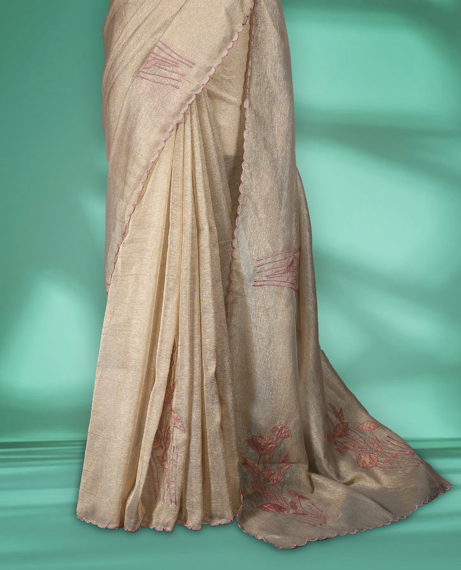 Beige gold colour organza designer saree featuring a subtle shimmer woven body with delicate green floral Soft mauve embroidery, scalloped thread detailing along the border and pallu paired with matching blouse.