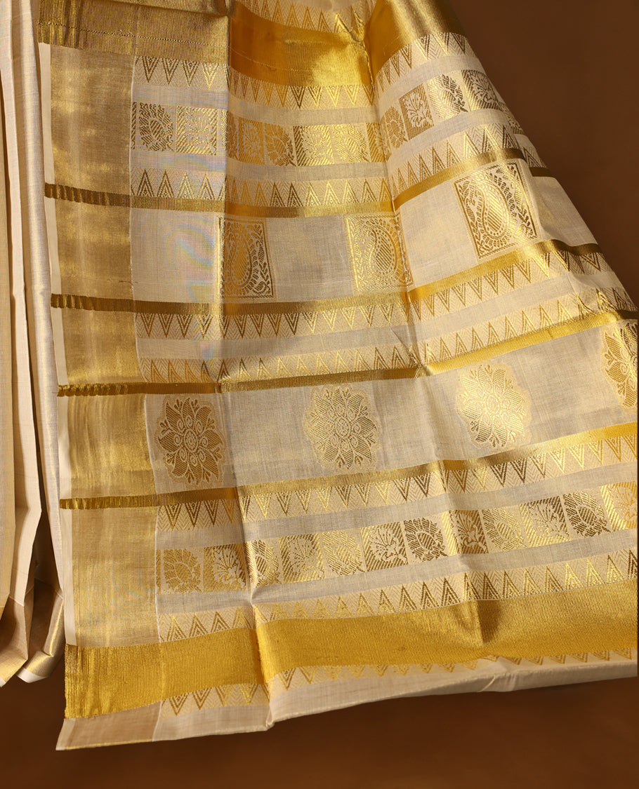 Elegant off white colour tissue Kerala saree with gold zari buttas, broad kasavu border, and richly woven traditional pallu. Crafted in cotton and paired with a matching blouse, perfect for festive and traditional occasions.