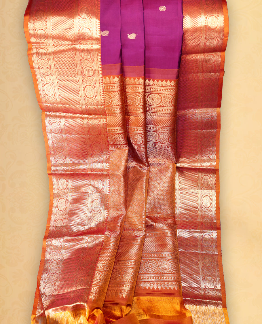 Wine colour pure Kancheepuram saree with gold zari small Mayoora chackara motifs on the body traditional contrast border with floral kodi motifs grand gold zari woven pallu paired with contrast matching blouse