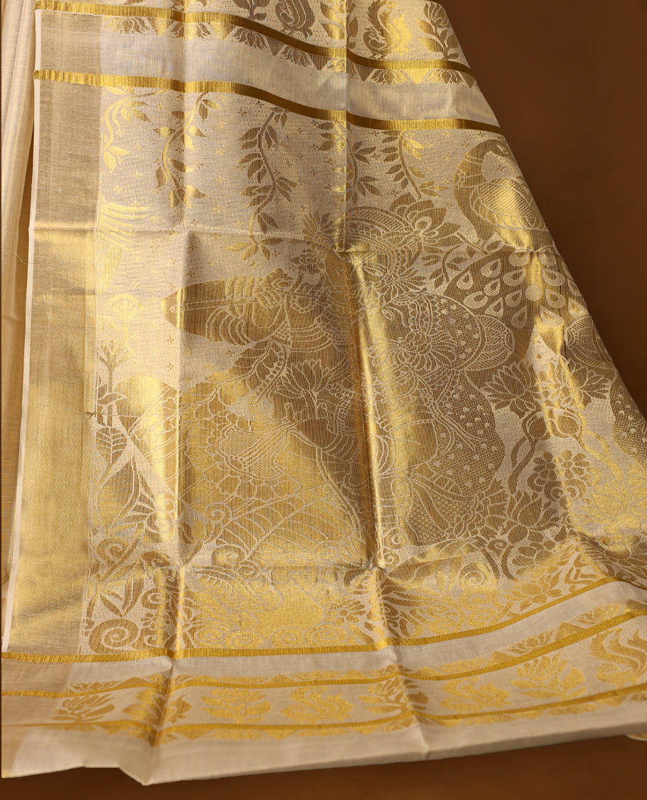 Elegant Light Gold colour Tissue Kerala saree featuring gold zari motifs on body, traditional golden zari kasavu border & Rich Pallu offering a classic and graceful look, paired with a matching blouse.